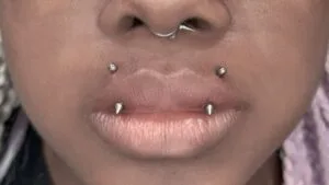 septum and angel fangs piercings on lower face