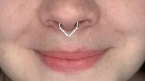 septum piercing with v shaped jewelry on smiling face