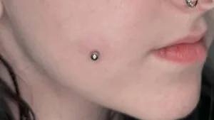 woman side face with cheek piercing 