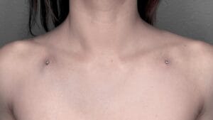 symmetrical collarbone dermal piercings on woman chest