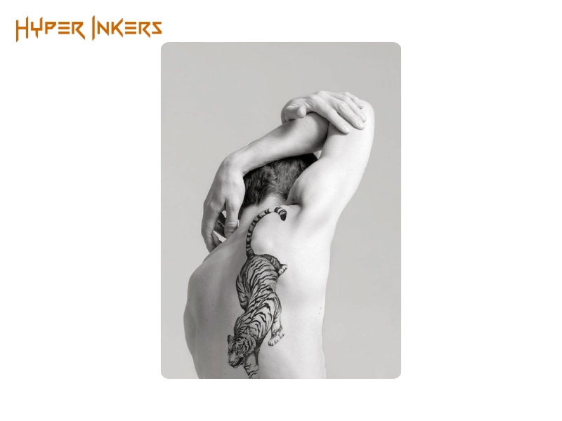 spine tattoo placement - Hyper Inkers Embodying raw power and independence, a tiger placed to move with the body is a timeless symbol of masculine strength.