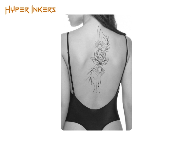 between shoulder blades tattoo ideas - Hyper Inkers A graceful composition of a lotus and celestial elements flowing down the spine, creating a statement of balance and enlightenment.
