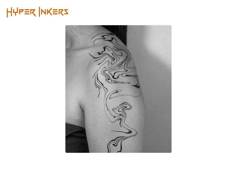 Marbled line-work tattoo covering the shoulder cap and running onto the upper arm