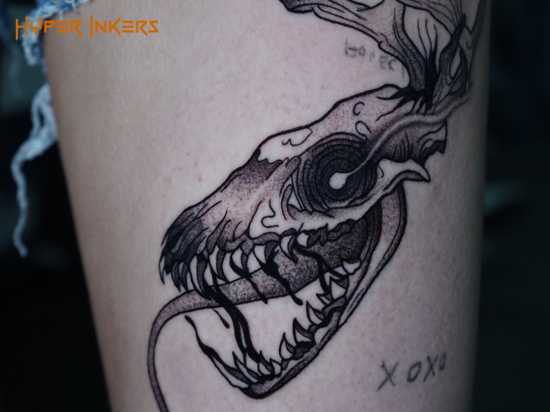 Sketch tattoo of an animal skull with visible hatching and construction lines on the thigh